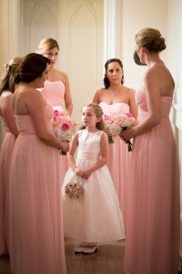 A flower girl surrounded by bridesmaids